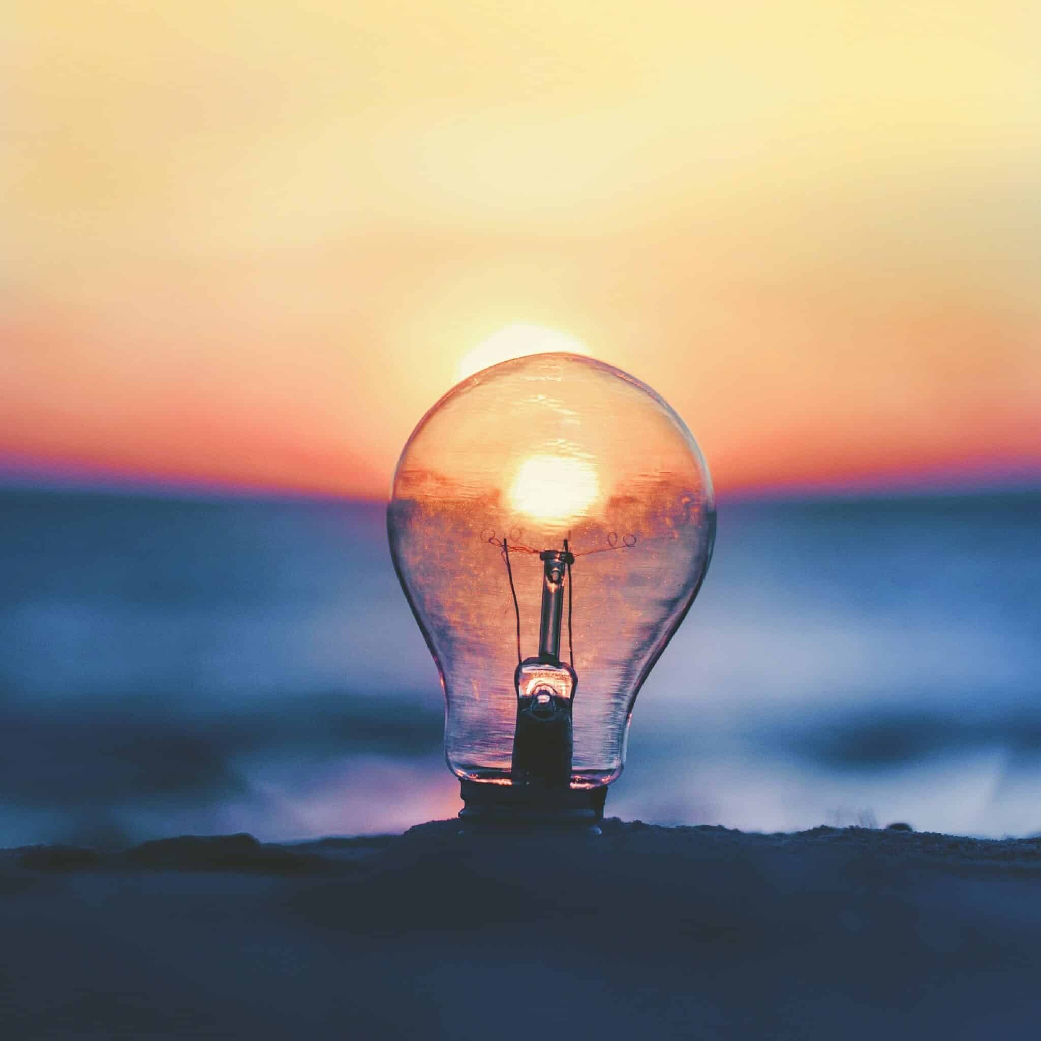 a lightbulb with a sunset in the background
